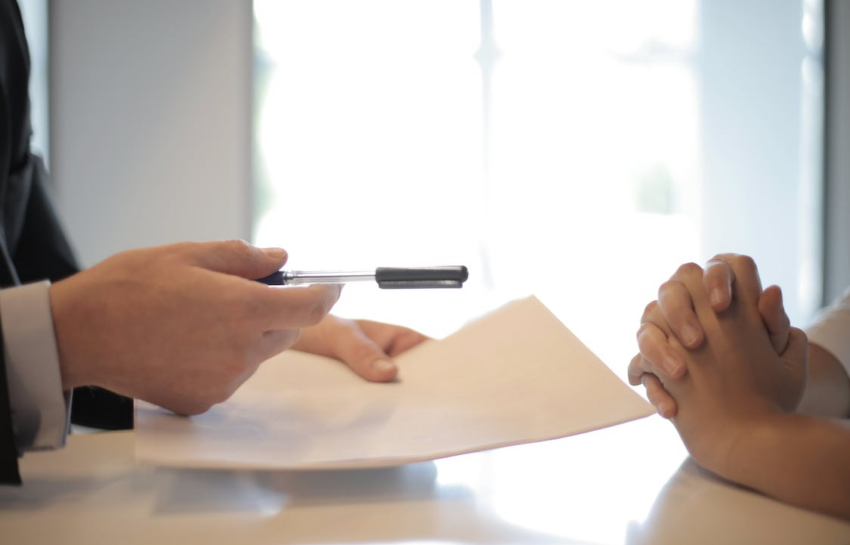 An Agent Offering a Pen and Paper to a Candidate