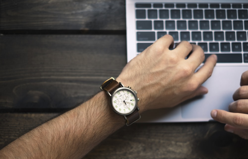 A Broadcast Journalist Types with a Wristwatch-bearing Hand