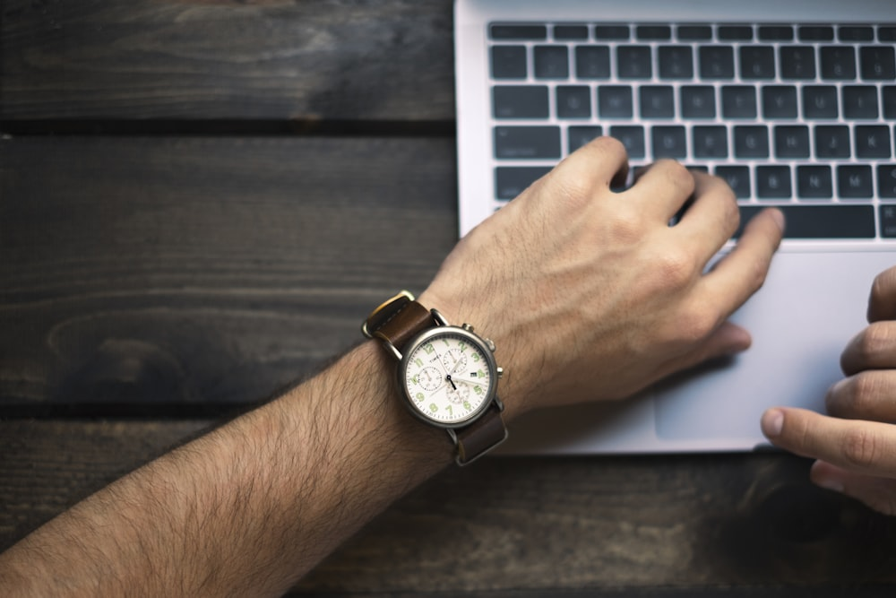 A Broadcast Journalist Types with a Wristwatch-bearing Hand