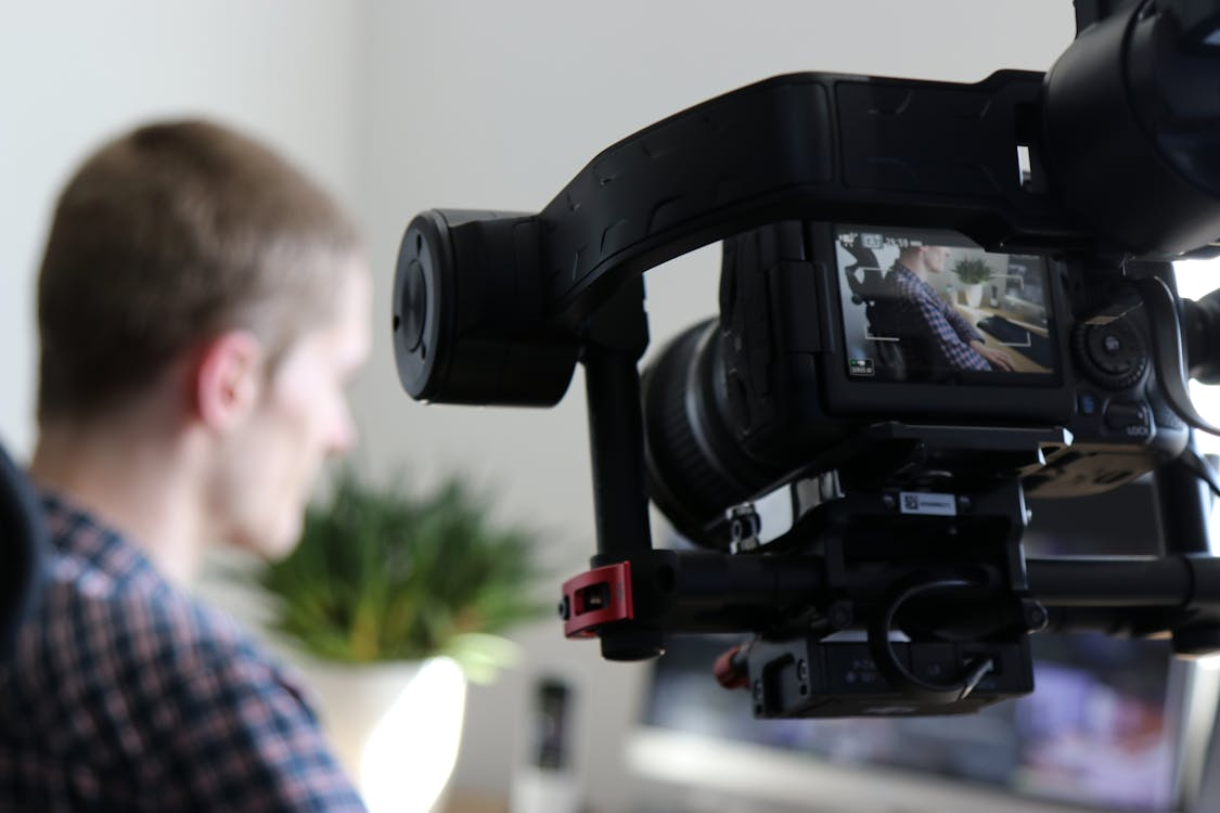 A video camera recording a man in a black shirt  