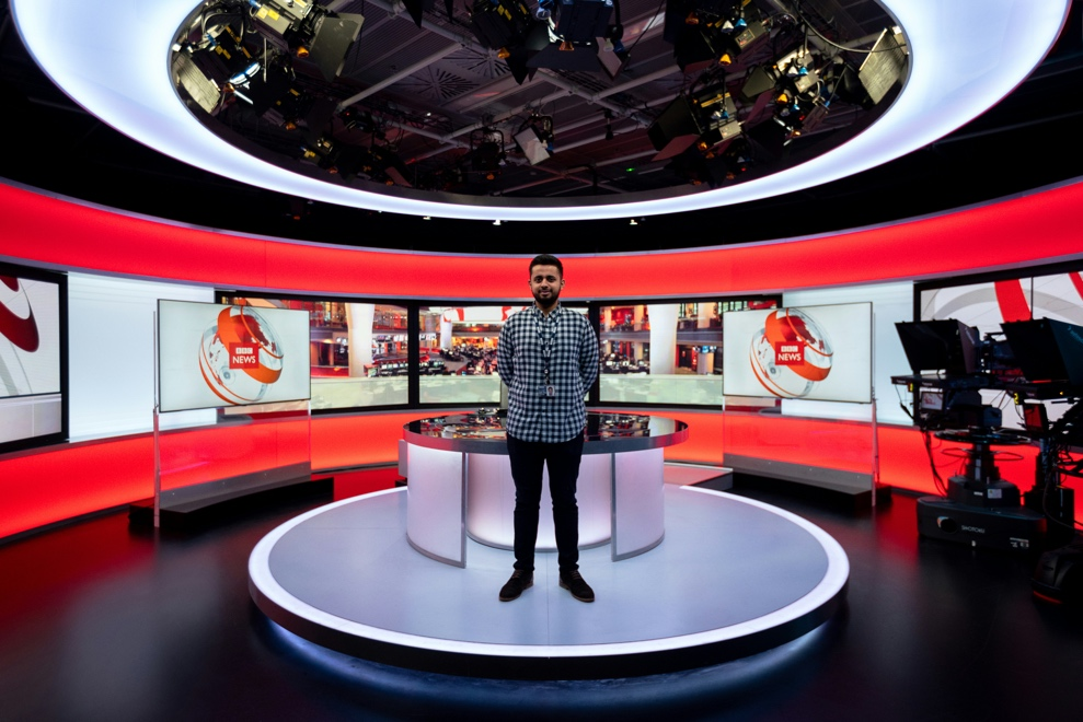  A man standing in a newsroom 