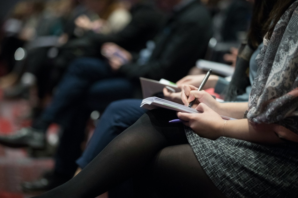 People in a conference taking notes 