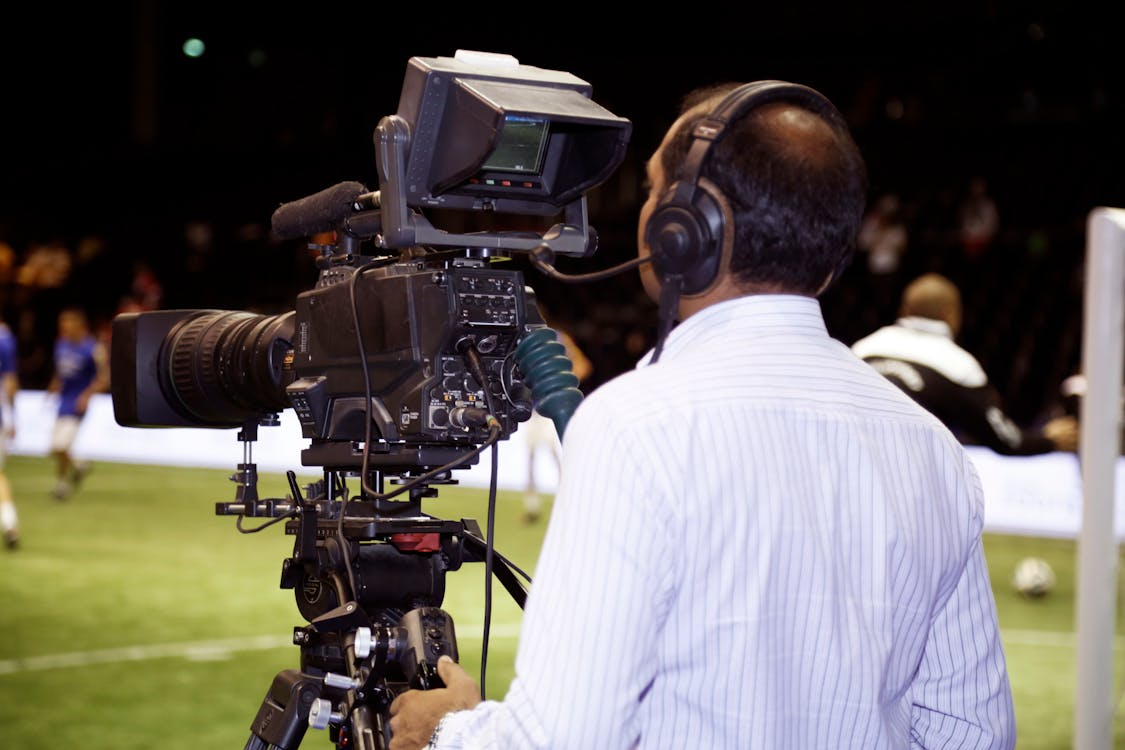 A man filming a soccer match