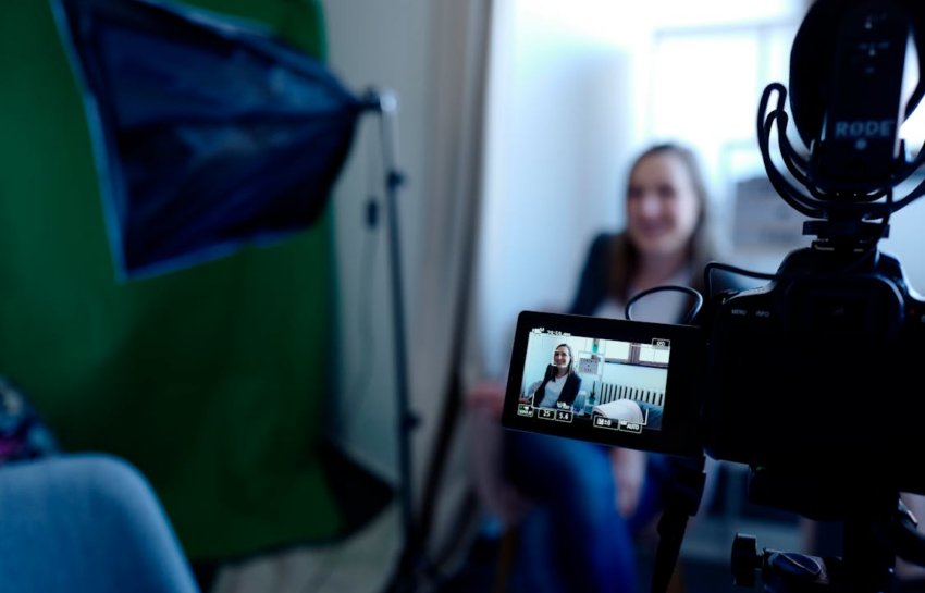 A video camera recording a smiling woman