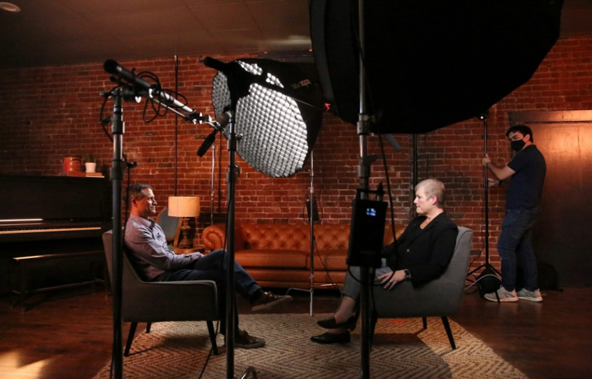 A journalist interviewing another person in a recording room