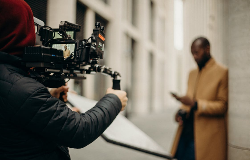 A journalist recording using a professional camera by https://www.pexels.com/photo/person-with-professional-camera-3206120/