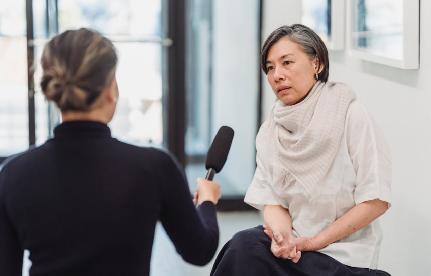 A woman holding a mic as she interviews an elder woman by https://www.pexels.com/photo/a-woman-being-interviewed-by-a-reporter-7859553/